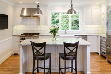 Inspiration for a mid-sized cottage l-shaped medium tone wood floor eat-in kitchen remodel in Richmond with a farmhouse sink, shaker cabinets, white cabinets, granite countertops, white backsplash, subway tile backsplash, stainless steel appliances and an island