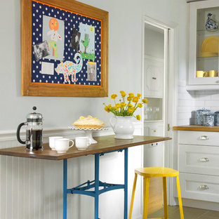 Small country galley eat-in kitchen in St Louis with a farmhouse sink, shaker cabinets, white cabinets, wood benchtops, white splashback, subway tile splashback, stainless steel appliances, porcelain floors and with island.