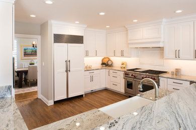 Mid-sized cottage u-shaped medium tone wood floor kitchen photo in San Francisco with a farmhouse sink, recessed-panel cabinets, white cabinets, granite countertops, white backsplash, subway tile backsplash and stainless steel appliances