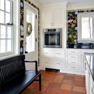 Foto di una cucina country con lavello sottopiano, ante in stile shaker, ante bianche, elettrodomestici in acciaio inossidabile e pavimento in terracotta