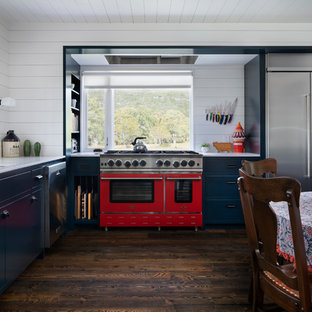 This is an example of a country separate kitchen in Austin with a drop-in sink, turquoise cabinets, quartz benchtops, white splashback, dark hardwood floors, brown floor and yellow benchtop.
