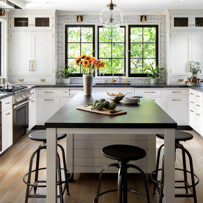 Enclosed kitchen - mid-sized cottage u-shaped light wood floor and brown floor enclosed kitchen idea in New York with an undermount sink, shaker cabinets, granite countertops, gray backsplash, colored appliances, an island, white cabinets, matchstick tile backsplash and black countertops