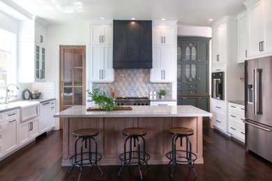 Large transitional u-shaped dark wood floor and brown floor open concept kitchen photo in Denver with a farmhouse sink, recessed-panel cabinets, light wood cabinets, quartzite countertops, blue backsplash, ceramic backsplash, stainless steel appliances, an island and gray countertops