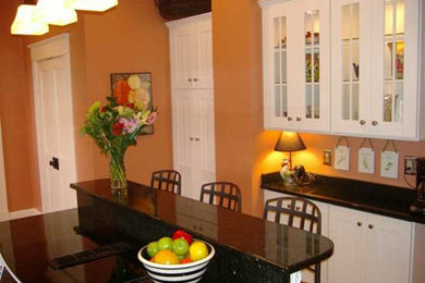 Mid-sized elegant kitchen photo in Atlanta with shaker cabinets, white cabinets, granite countertops and an island
