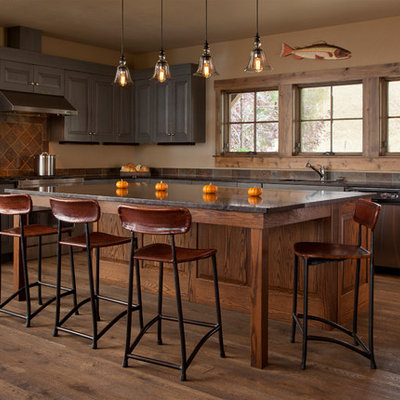 Inspiration for a mid-sized rustic l-shaped dark wood floor kitchen remodel in Other with an undermount sink, raised-panel cabinets, brown cabinets, brown backsplash, stainless steel appliances and an island