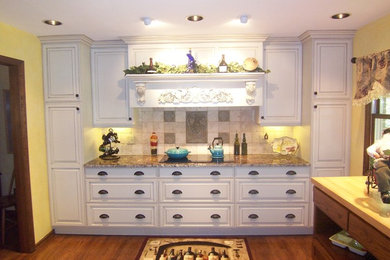 Exempel på ett stort lantligt kök, med en undermonterad diskho, luckor med upphöjd panel, vita skåp, granitbänkskiva, vitt stänkskydd, stänkskydd i stenkakel, integrerade vitvaror och mellanmörkt trägolv