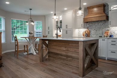 Mid-sized farmhouse l-shaped medium tone wood floor, multicolored floor and exposed beam eat-in kitchen photo in Other with an undermount sink, shaker cabinets, white cabinets, quartzite countertops, multicolored backsplash, mosaic tile backsplash, stainless steel appliances, an island and multicolored countertops