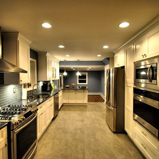 Mid-sized traditional galley eat-in kitchen in New York with an undermount sink, shaker cabinets, white cabinets, quartz benchtops, grey splashback, ceramic splashback, stainless steel appliances, porcelain floors and a peninsula.