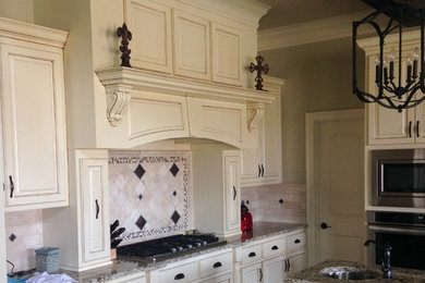 Inspiration for a timeless galley kitchen pantry remodel in New Orleans with raised-panel cabinets, white cabinets, granite countertops, beige backsplash, stone tile backsplash and an island