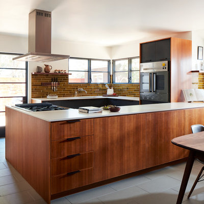 Mid-century modern u-shaped gray floor eat-in kitchen photo in San Francisco with an undermount sink, flat-panel cabinets, medium tone wood cabinets, brown backsplash, black appliances, a peninsula and white countertops
