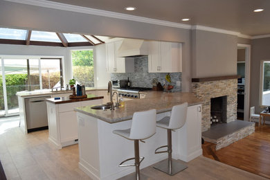 Example of a large minimalist u-shaped vinyl floor and gray floor open concept kitchen design in San Francisco with an undermount sink, shaker cabinets, white cabinets, quartz countertops, blue backsplash, mosaic tile backsplash, stainless steel appliances, an island and gray countertops