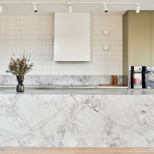 Inspiration for a large modern galley eat-in kitchen in Melbourne with flat-panel cabinets, green cabinets, marble benchtops, white splashback, ceramic splashback, stainless steel appliances, light hardwood floors, with island, beige floor, white benchtop and an undermount sink.