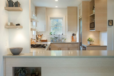 Example of a 1950s light wood floor kitchen design in Detroit with an undermount sink, flat-panel cabinets, light wood cabinets and stainless steel appliances