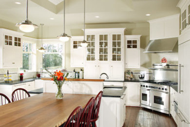 Large cottage u-shaped dark wood floor and brown floor eat-in kitchen photo in Sacramento with an undermount sink, shaker cabinets, white cabinets, soapstone countertops, paneled appliances and an island