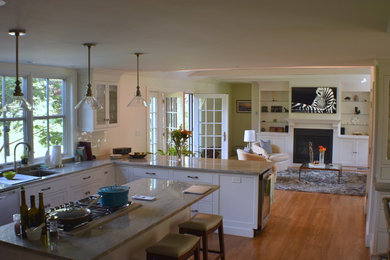 ボストンにある広いトランジショナルスタイルのおしゃれなキッチン (アンダーカウンターシンク、インセット扉のキャビネット、御影石カウンター、白いキッチンパネル、セラミックタイルのキッチンパネル、シルバーの調理設備、無垢フローリング、ベージュの床、ベージュのキッチンカウンター、白いキャビネット) の写真