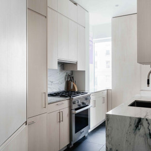 Immagine di una piccola cucina a L minimal con lavello sottopiano, ante lisce, ante in legno chiaro, paraspruzzi grigio, nessuna isola, pavimento nero e top grigio