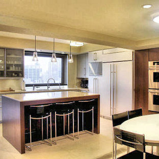 Inspiration for an expansive modern u-shaped separate kitchen in New York with an undermount sink, flat-panel cabinets, stainless steel cabinets, solid surface benchtops, metallic splashback, metal splashback, stainless steel appliances, with island and porcelain floors.