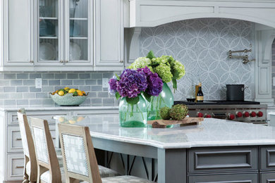 Inspiration for a coastal eat-in kitchen remodel in Wilmington with a farmhouse sink, recessed-panel cabinets, gray cabinets, marble countertops, gray backsplash, stone tile backsplash and stainless steel appliances