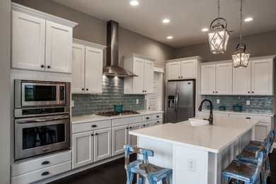 Kitchen - l-shaped kitchen idea in Indianapolis with white cabinets, blue backsplash, ceramic backsplash, stainless steel appliances and an island