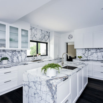 Kitchen with white shaker profile cabinets and marble benchtops