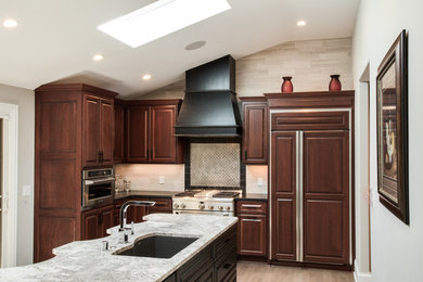 Example of a huge l-shaped light wood floor eat-in kitchen design in Milwaukee with granite countertops, a double-bowl sink, raised-panel cabinets, medium tone wood cabinets, beige backsplash, ceramic backsplash, stainless steel appliances and an island