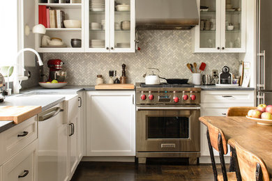 ニューヨークにあるトラディショナルスタイルのおしゃれなキッチン (白いキャビネット、エプロンフロントシンク、シェーカースタイル扉のキャビネット、グレーのキッチンパネル、シルバーの調理設備、濃色無垢フローリング、アイランドなし、茶色い床) の写真