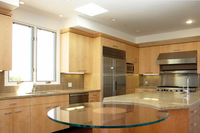 Example of a mid-sized transitional l-shaped open concept kitchen design in Other with an undermount sink, flat-panel cabinets, light wood cabinets, glass countertops, beige backsplash, porcelain backsplash, stainless steel appliances and an island