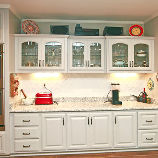 Photo of a traditional u-shaped separate kitchen in Milwaukee with a double-bowl sink, louvered cabinets, white cabinets, granite benchtops, white splashback, subway tile splashback, stainless steel appliances, vinyl floors and with island.