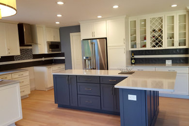 Kitchen - mid-sized transitional u-shaped light wood floor and beige floor kitchen idea in Other with an undermount sink, shaker cabinets, white cabinets, solid surface countertops, blue backsplash, porcelain backsplash, stainless steel appliances, an island and gray countertops
