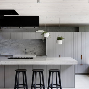 Photo of a contemporary galley open plan kitchen in Melbourne with a farmhouse sink, flat-panel cabinets, grey cabinets, grey splashback, with island and beige floor.