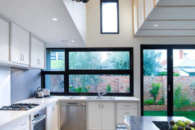 Esempio di una cucina abitabile minimal con ante bianche e pavimento grigio