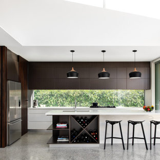 Inspiration for a contemporary l-shaped kitchen in Sydney with an undermount sink, flat-panel cabinets, dark wood cabinets, window splashback, stainless steel appliances, concrete floors, with island, grey floor and white benchtop.