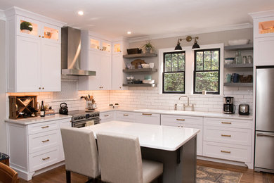 Mid-sized arts and crafts l-shaped medium tone wood floor and brown floor eat-in kitchen photo in Atlanta with an undermount sink, shaker cabinets, white cabinets, quartz countertops, white backsplash, subway tile backsplash, stainless steel appliances, an island and white countertops