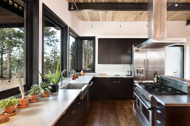 Exempel på ett stort modernt u-kök, med en rustik diskho, släta luckor, rostfria vitvaror, en köksö, svarta skåp, marmorbänkskiva, vitt stänkskydd och mellanmörkt trägolv