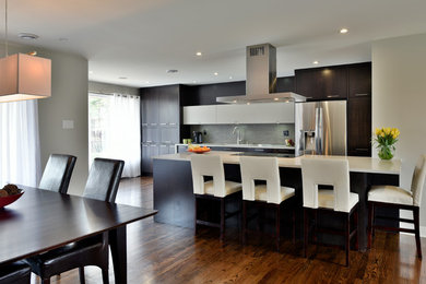 Eat-in kitchen - mid-sized modern galley medium tone wood floor eat-in kitchen idea in Ottawa with flat-panel cabinets, dark wood cabinets, quartz countertops and an island