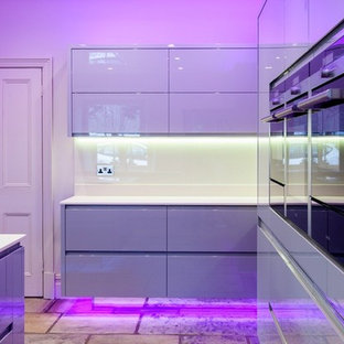 Inspiration for a large modern galley open plan kitchen in Other with a drop-in sink, flat-panel cabinets, grey cabinets, laminate benchtops, white splashback, stainless steel appliances, brick floors and with island.
