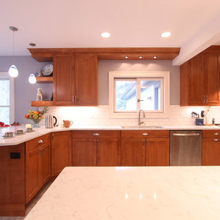 Foto de cocina comedor en U, clásica renovada, grande, con fregadero bajoencimera, armarios con paneles empotrados, puertas de armario de madera oscura, encimera de cuarzo compacto, salpicadero blanco, salpicadero de azulejos de cerámica, electrodomésticos de acero inoxidable, suelo vinílico y península