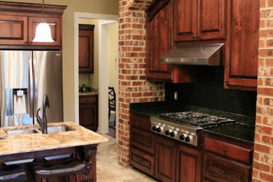 Kitchen in New Orleans with dark wood cabinets, granite worktops, stainless steel appliances and porcelain flooring.