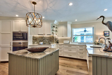 Open concept kitchen - mid-sized transitional u-shaped medium tone wood floor open concept kitchen idea in Miami with an undermount sink, shaker cabinets, white cabinets, granite countertops, stainless steel appliances, an island, stone slab backsplash and multicolored backsplash