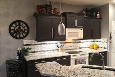 Example of a mid-sized minimalist galley ceramic tile eat-in kitchen design in Seattle with an undermount sink, shaker cabinets, dark wood cabinets, quartz countertops, white backsplash, ceramic backsplash, stainless steel appliances and a peninsula