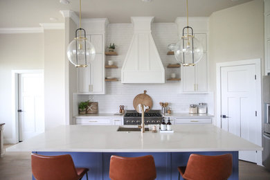 Eat-in kitchen - mid-sized transitional single-wall light wood floor and brown floor eat-in kitchen idea in Dallas with an undermount sink, shaker cabinets, white cabinets, quartz countertops, white backsplash, ceramic backsplash, stainless steel appliances, an island and white countertops