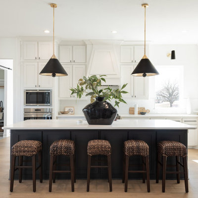 Example of a large transitional l-shaped light wood floor and beige floor open concept kitchen design in Dallas with shaker cabinets, white cabinets, quartzite countertops, white backsplash, stainless steel appliances, an island and white countertops