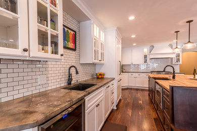 ミネアポリスにあるお手頃価格の広いコンテンポラリースタイルのおしゃれなキッチン (アンダーカウンターシンク、ガラス扉のキャビネット、白いキャビネット、白いキッチンパネル) の写真