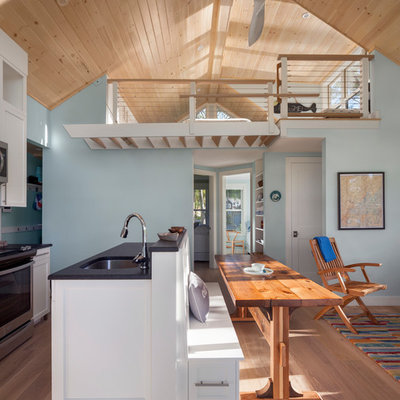 Inspiration for a small coastal medium tone wood floor and brown floor open concept kitchen remodel in Portland Maine with an undermount sink, shaker cabinets, white cabinets, granite countertops, stainless steel appliances and an island