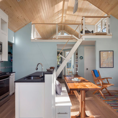 Inspiration for a small coastal medium tone wood floor and brown floor open concept kitchen remodel in Portland Maine with an undermount sink, shaker cabinets, white cabinets, granite countertops, stainless steel appliances and an island