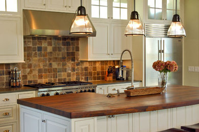 Inspiration for a coastal open concept kitchen remodel in Charleston with white cabinets, wood countertops, stone tile backsplash, stainless steel appliances and an island