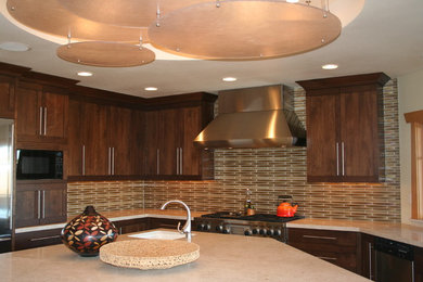 Photo of a contemporary enclosed kitchen in Boise with a submerged sink, flat-panel cabinets, medium wood cabinets, beige splashback, glass tiled splashback, stainless steel appliances and an island.