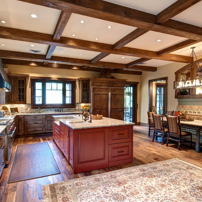 Example of a mountain style l-shaped eat-in kitchen design in Denver with raised-panel cabinets, dark wood cabinets, gray backsplash and paneled appliances