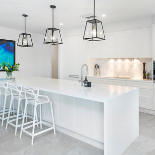Inspiration for a contemporary galley kitchen in Gold Coast - Tweed with shaker cabinets, white cabinets, grey splashback, stainless steel appliances, with island, grey floor and white benchtop.