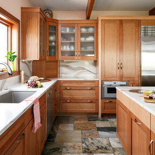 This is an example of an expansive transitional l-shaped separate kitchen in Louisville with an undermount sink, recessed-panel cabinets, medium wood cabinets, quartz benchtops, white splashback, stone slab splashback, stainless steel appliances, porcelain floors, multiple islands, multi-coloured floor and white benchtop.
